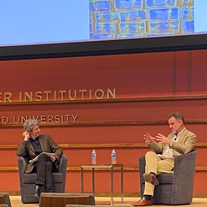 Alex de Waal and Niall Ferguson sitting on the stage of Hauck Auditorium