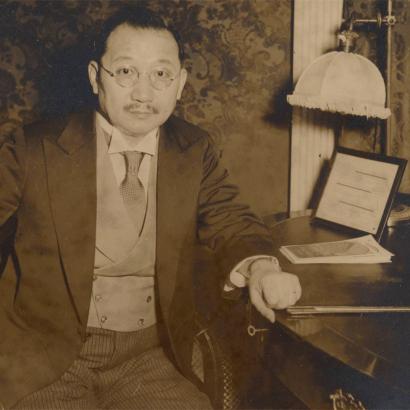 Sepia tone photograph of H. H. Kung seated at desk, 1930s