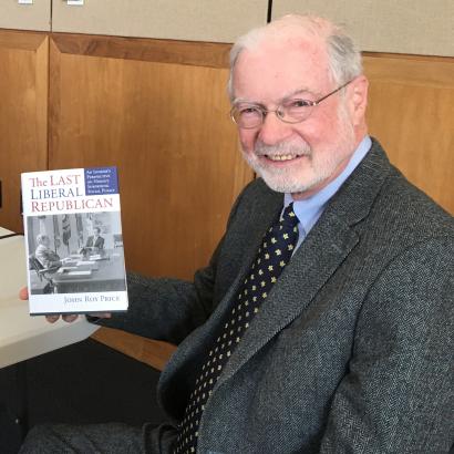 John Roy Price holding a copy of his book on President Nixon