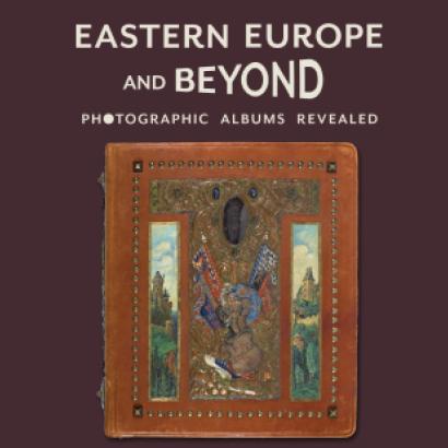 Purple background with title in cream above a leather bound photo album covered in paintings, metalwork, and jewels. Gajda Album