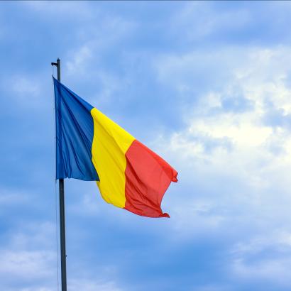Romanian national flag against romantic sky in Bucharest, Romania - stock photo