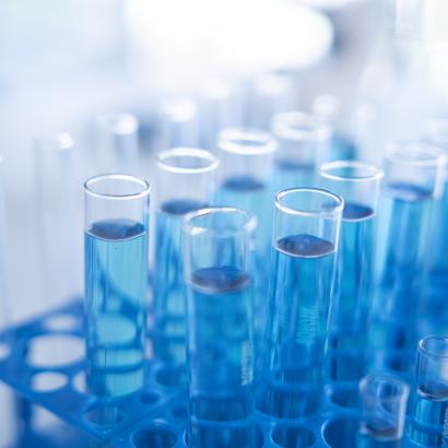 Science laboratory test tubes row with light blue liquid close-up - stock photo