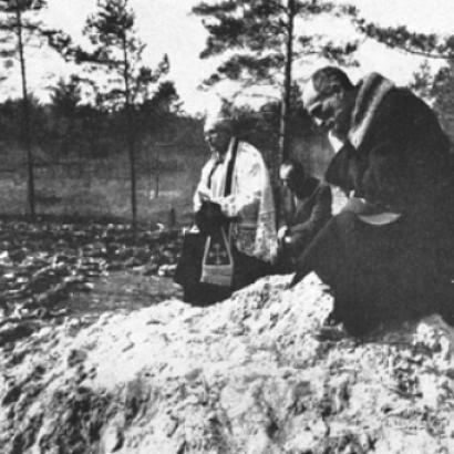 Father Stanislaw Jasinski, representative of the bishop of Krakow, prays over the mass graves