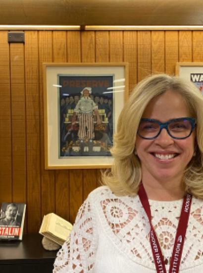 Roxanne Peck standing in front of a wall of posters and books on a table