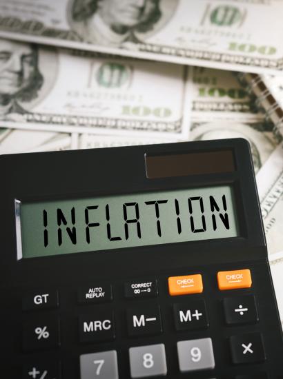 Calculator stating inflation with money in the background