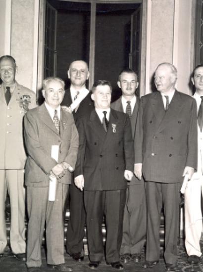 Group of men standing for a photo. Nicholas Feodoroff (front row center) with Herbert Hoover (front row right).