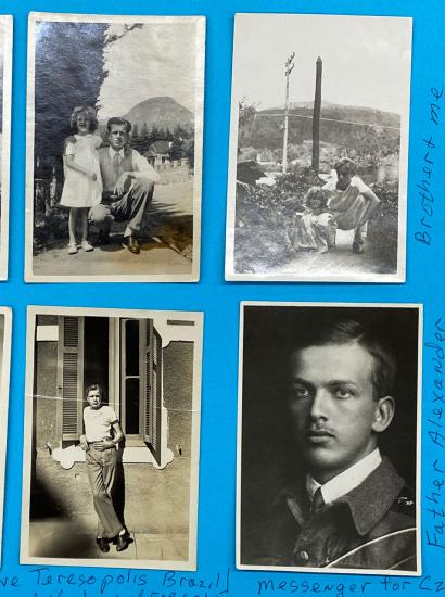 Six black and white photographs adhered to blue paper.