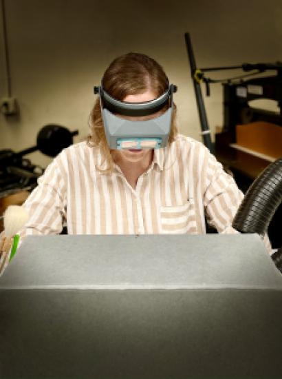 Photograph of person doing conservation work partially hidden by an archival box