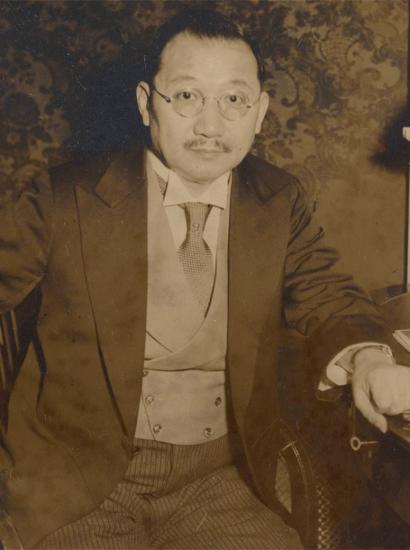 Sepia tone photograph of H. H. Kung seated at desk, 1930s