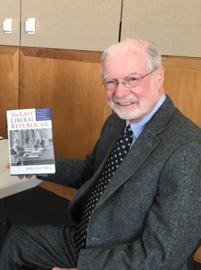 John Roy Price holding a copy of his book on President Nixon