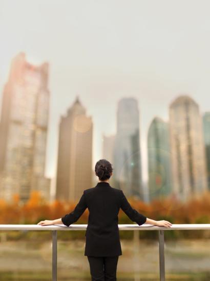 Young woman standing with view of buildings in city downtown