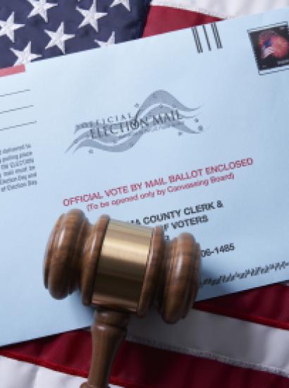 Voting ballot: Absentee voting by mail with ballot envelope on USA flag and gavel stock photo