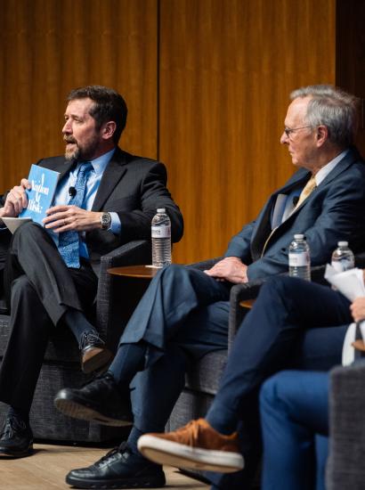 Hoover Education Success Initiative Director Stephen Bowen (left) holds a copy of the original 1983 A Nation at Risk report on US public education during a panel discussing the history of public education reform on January 10, 2025. (Patrick Beaudouin)