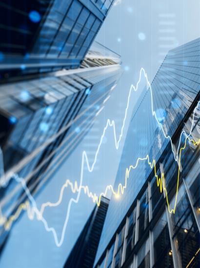 A double exposure image of skyscrapers with overlay of financial graphs, set against a blurred background, illustrating the concept of business growth stock photo