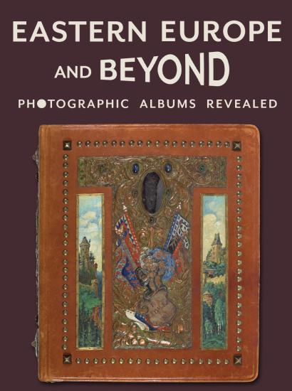 Purple background with title in cream above a leather bound photo album covered in paintings, metalwork, and jewels. Gajda Album