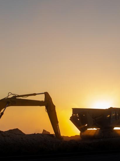 Construction machinery in the rays of the rising sun, early morning at the construction site stock photo