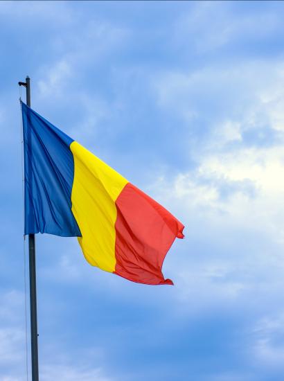Romanian national flag against romantic sky in Bucharest, Romania - stock photo