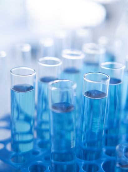 Science laboratory test tubes row with light blue liquid close-up - stock photo