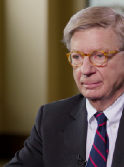 Image of George F. Will sitting at a table.