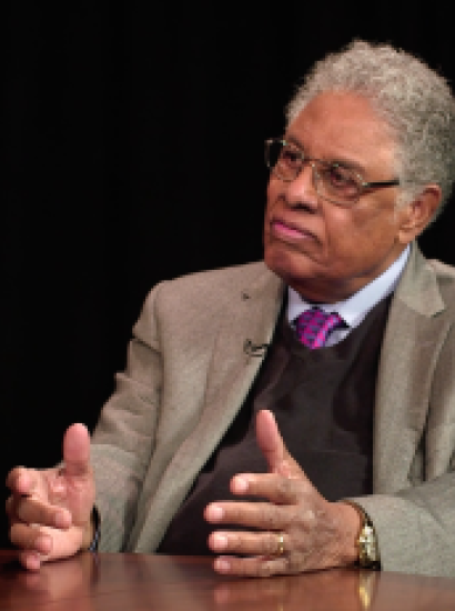 Thomas Sowell in front of a black background with an Uncommon Knowledge mug