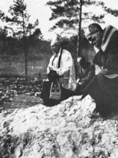 Father Stanislaw Jasinski, representative of the bishop of Krakow, prays over the mass graves