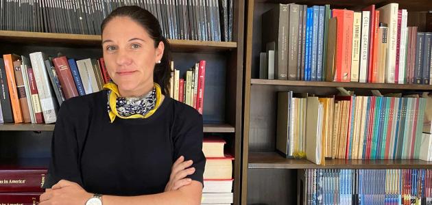 Katharina Friedla standing in front of book case