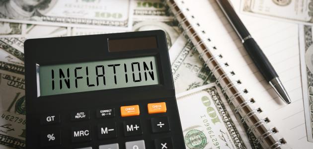 Calculator stating inflation with money in the background