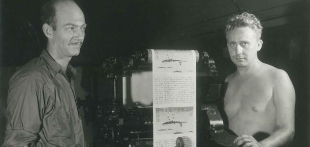 Two men operating a print press at the Office of War Information