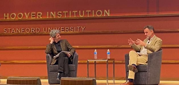 Alex de Waal and Niall Ferguson sitting on the stage of Hauck Auditorium