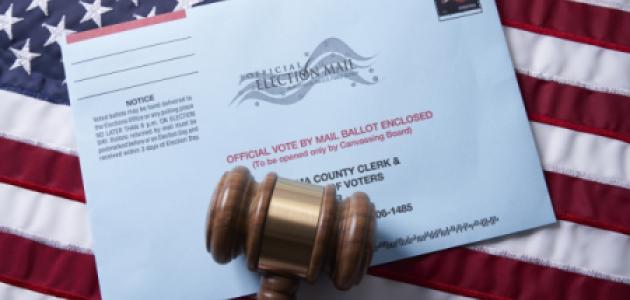 Voting ballot: Absentee voting by mail with ballot envelope on USA flag and gavel stock photo