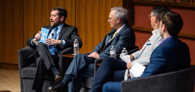 Hoover Education Success Initiative Director Stephen Bowen (left) holds a copy of the original 1983 A Nation at Risk report on US public education during a panel discussing the history of public education reform on January 10, 2025. (Patrick Beaudouin)