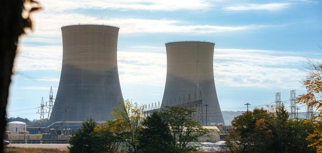 Green Trees surrounding the tall Cooling Towers of a Nuclear Power Plant in Tennessee on a Sunny Autumn Day stock photo