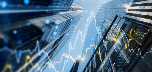 A double exposure image of skyscrapers with overlay of financial graphs, set against a blurred background, illustrating the concept of business growth stock photo