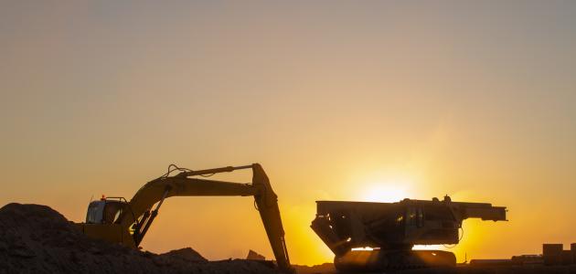 Construction machinery in the rays of the rising sun, early morning at the construction site stock photo