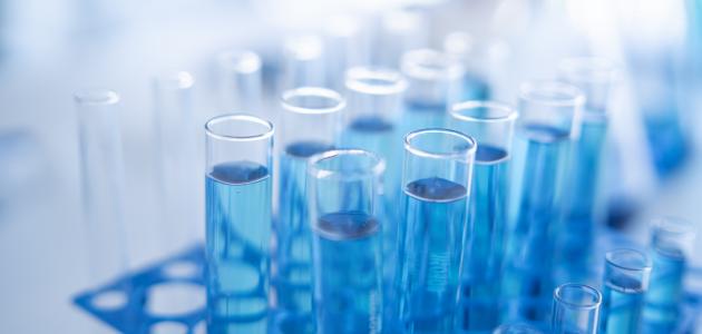Science laboratory test tubes row with light blue liquid close-up - stock photo