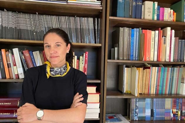 Katharina Friedla standing in front of book case