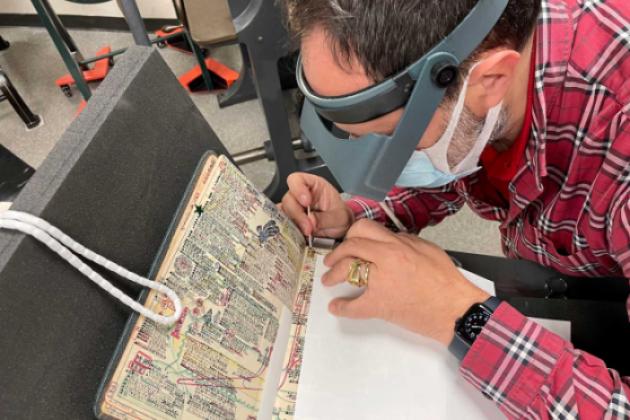 Laurent Cruveillier wearing magnifying goggle during conservation treatment of the Kitaji Bibles