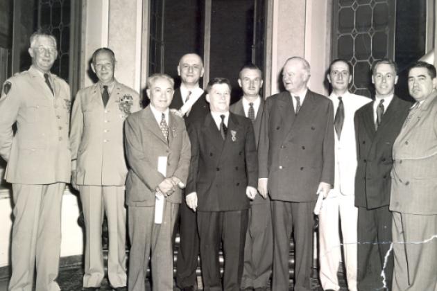 Group of men standing for a photo. Nicholas Feodoroff (front row center) with Herbert Hoover (front row right).