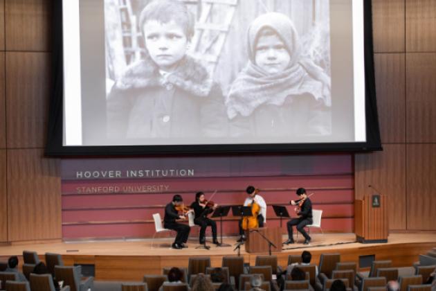 Film on a screen with a string quartet playing below