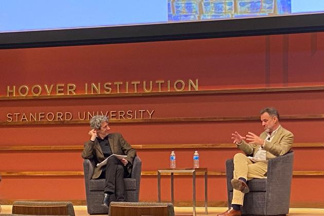 Alex de Waal and Niall Ferguson sitting on the stage of Hauck Auditorium