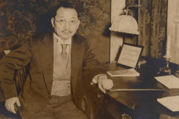 Sepia tone photograph of H. H. Kung seated at desk, 1930s