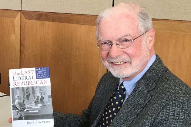 John Roy Price holding a copy of his book on President Nixon