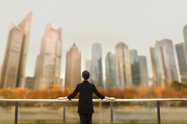 Young woman standing with view of buildings in city downtown