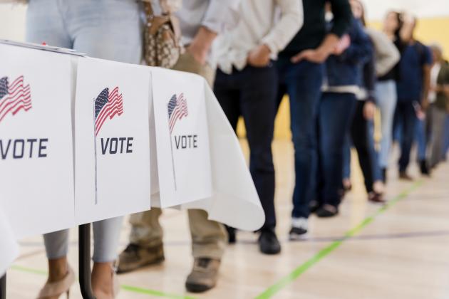Low angle view of people lined up to vote stock photo