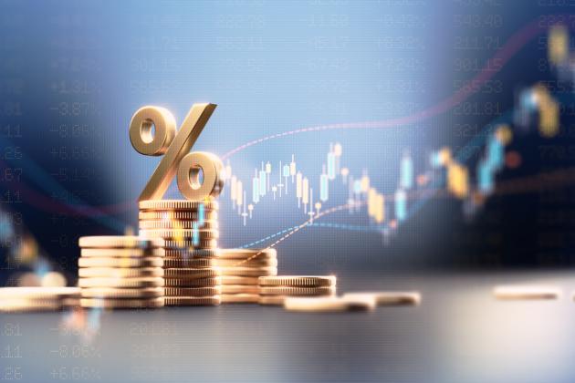 Percentage Sign On Top Of Coin Stacks Before Blue Financial Graph stock photo