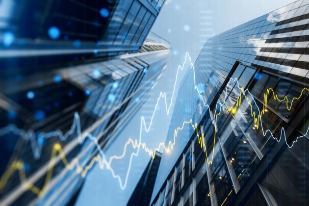 A double exposure image of skyscrapers with overlay of financial graphs, set against a blurred background, illustrating the concept of business growth stock photo