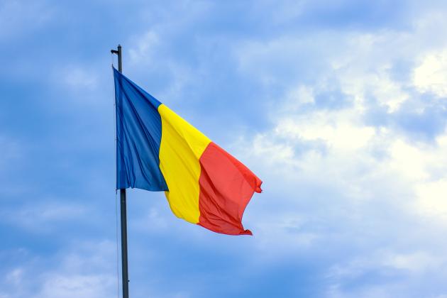 Romanian national flag against romantic sky in Bucharest, Romania - stock photo