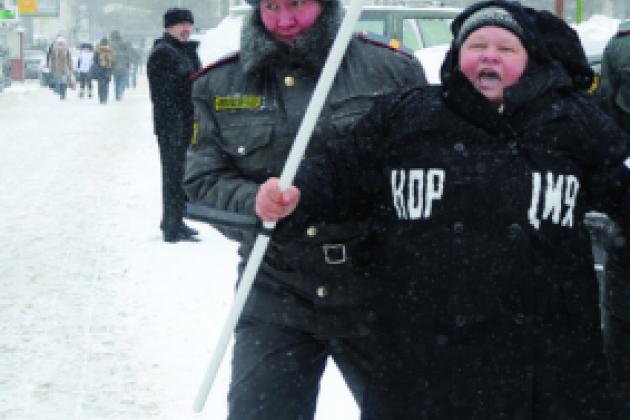 Moscow police officer detains a demonstrator