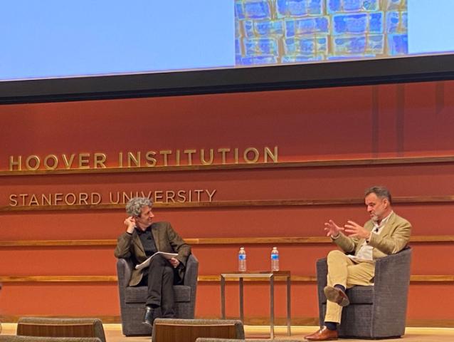 Alex de Waal and Niall Ferguson sitting on the stage of Hauck Auditorium