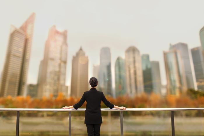 Young woman standing with view of buildings in city downtown